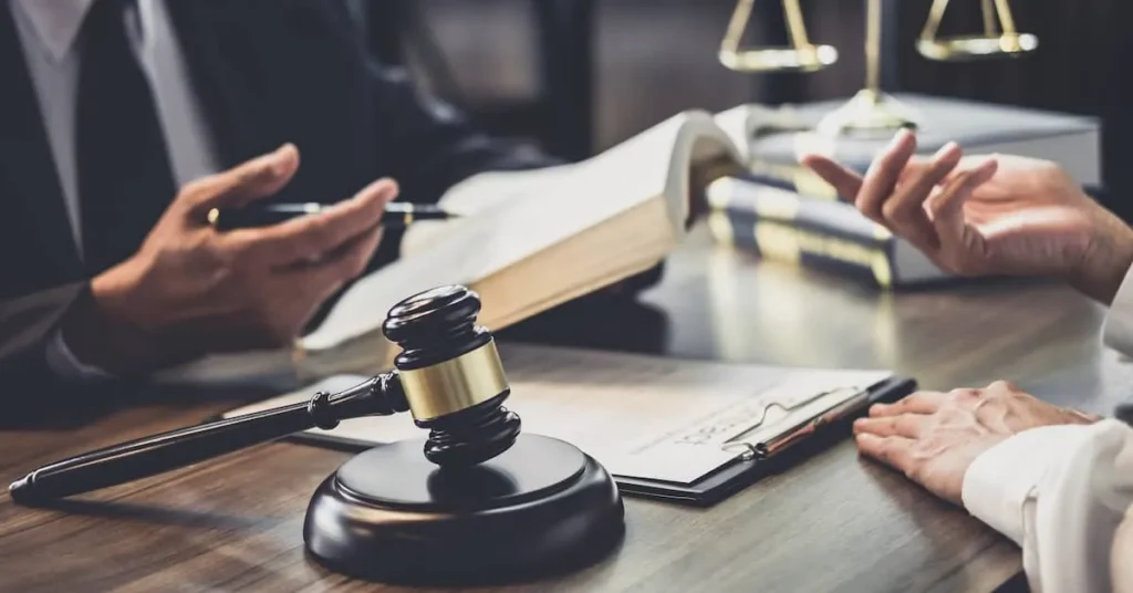 Mass Tort attorney meeting with client, with gavel and law books on desk